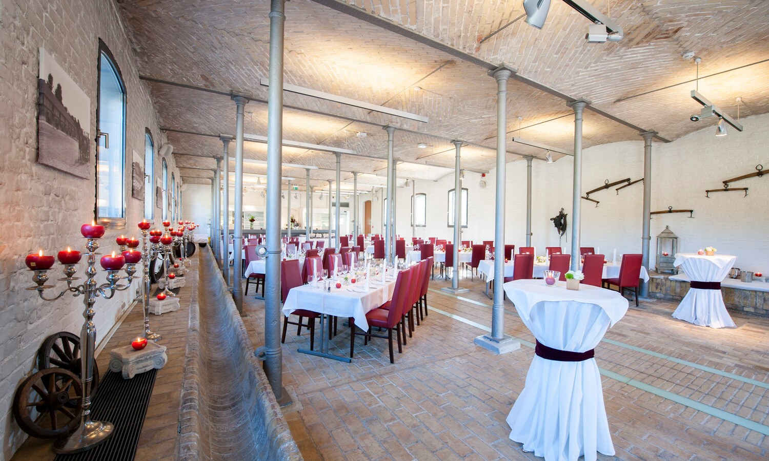 Eingedeckte Tische und Kerzenstaender im Ochsenstall